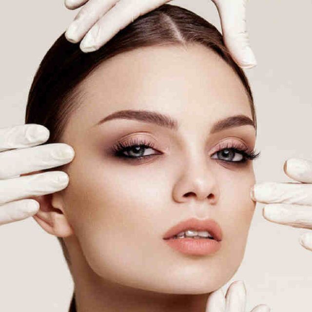 Woman receiving an aesthetic skin treatment from a gloved practitioner at 7 Derma Center