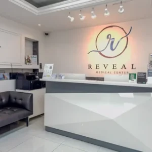 Reception and waiting area at Reveal Medical Center in Al Barsha, Dubai, with the clinic logo on the wall