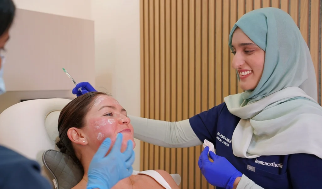 Doctor at loom:aesthetics examining a patient's skin in a treatment room
